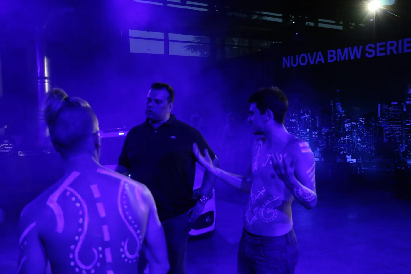 I performer BMW con le scritte sui corpi illuminate dai raggi UV